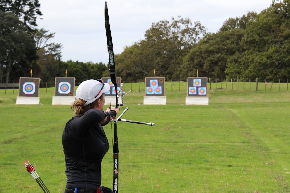 A person practicing archery in a field